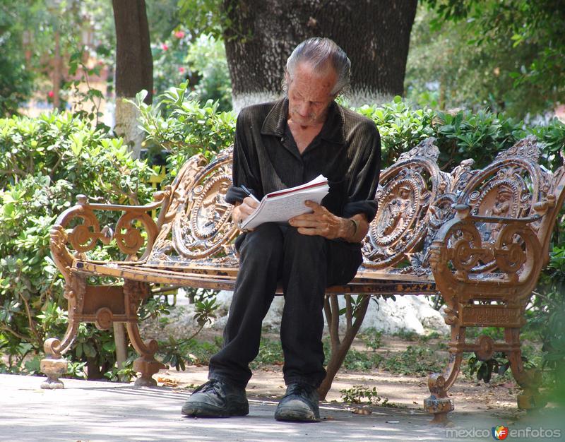 Señor escribiendo en la plaza principal