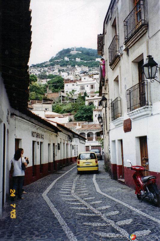 Calle empedrada con figuras en el centro de Taxco, Guerrero