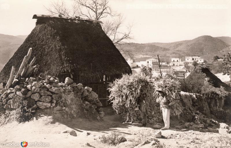 Un jacal y cargadores de leña